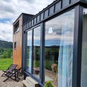 Tiny House  mit Empore – Panorama-Fensterfront über volle Höhe – Zeitgenössischer Chalet-Stil